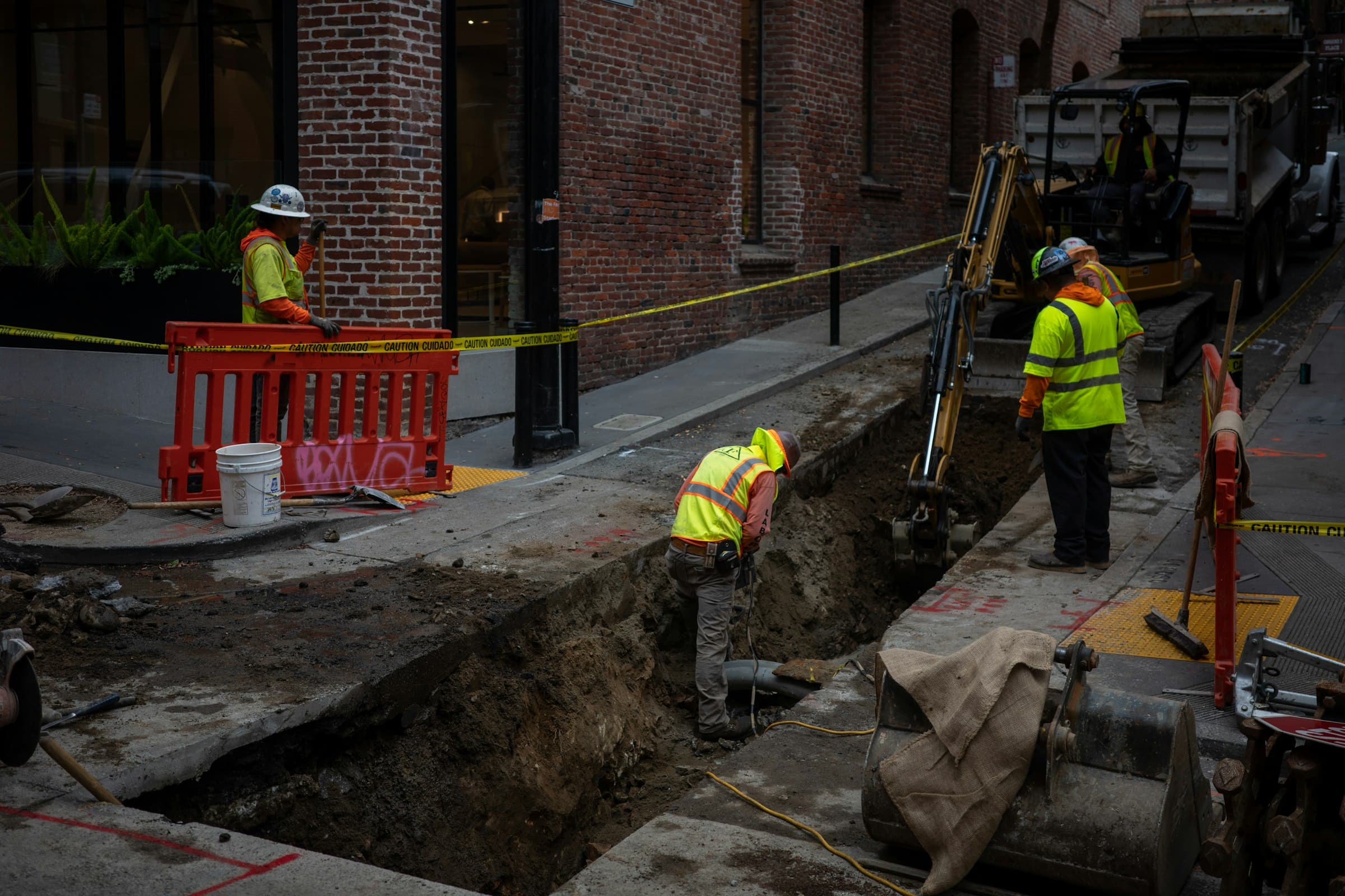 Workers excavating a road to reach underground services