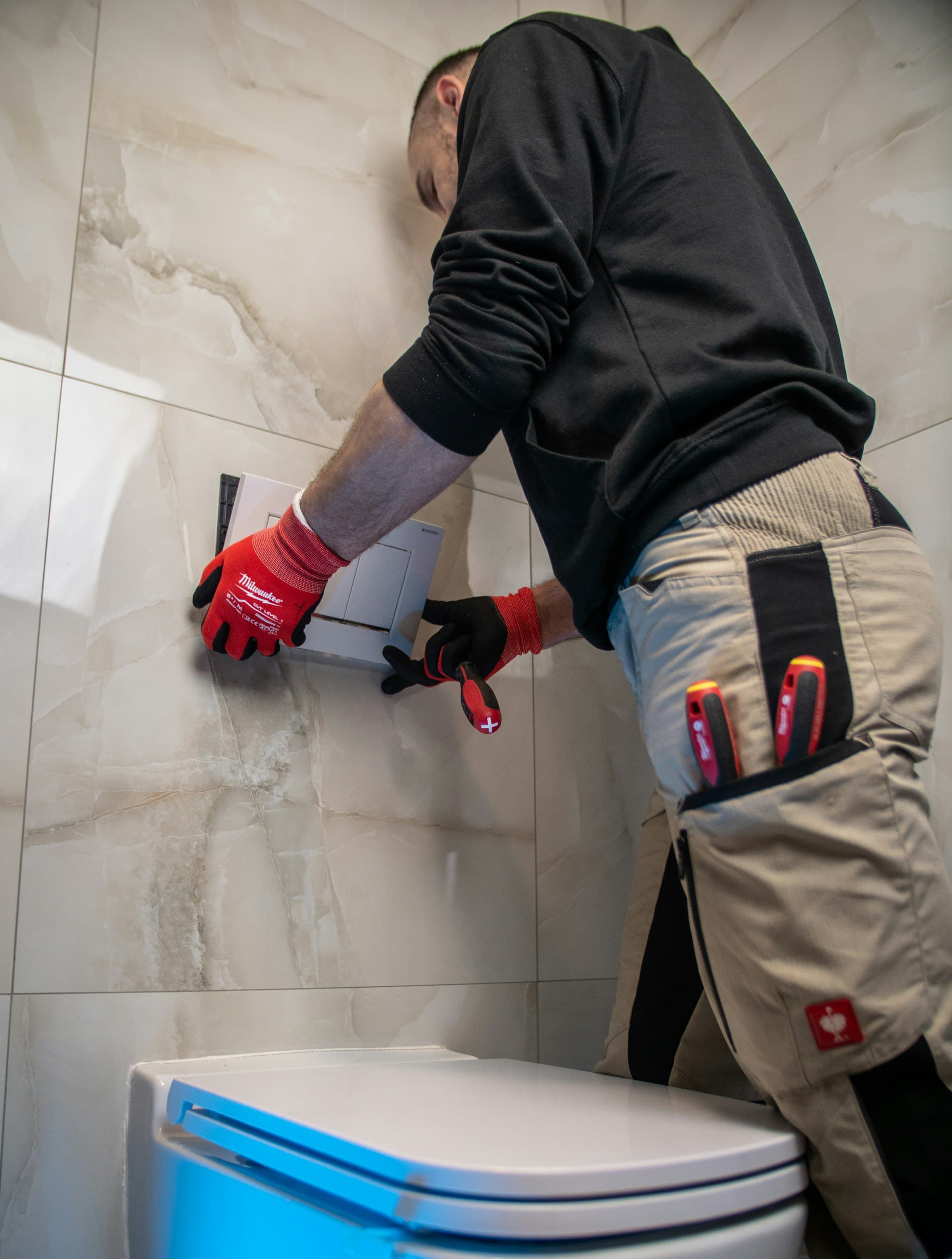 A plumber repairing a toilet cistern