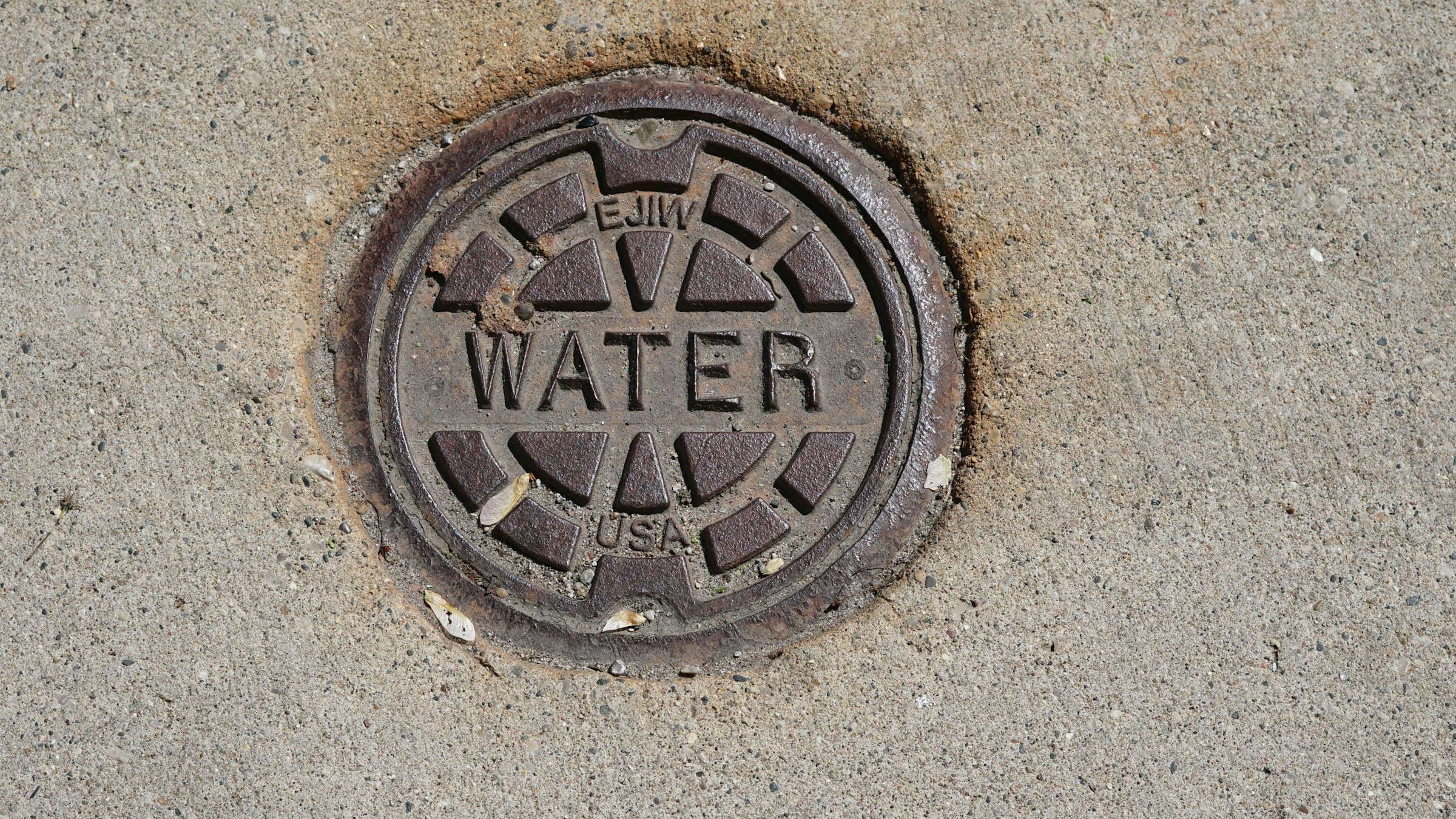 A water meter cover set into a Perth footpath